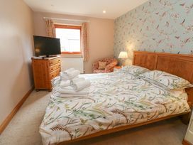 A bedroom with a bed and television at Cooper Cottage in Potto near Stokesley