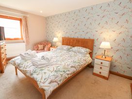 A bedroom with a bed and nightstand at Cooper Cottage Potto near Stokesley