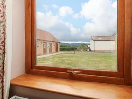 A view from a window showing grass and buildings at Cooper Cottage Potto near Stokesley