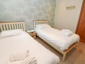 A bedroom with two single beds and a bedside table at Cooper Cottage in Potto near Stokesley
