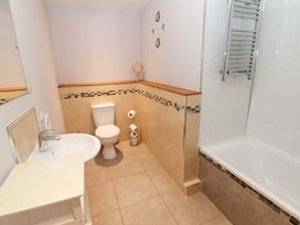 A bathroom with a toilet, sink, bathtub, and towel rack at Cooper Cottage near Potto