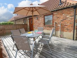 An outdoor dining area with a table and chairs at Cooper Cottage in Potto near Stokesley