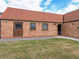 An outdoor view of a brick building with a door and windows at Cooper Cottage in Potto near Stokesley