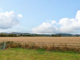 A field with a fence and mountains in the background at Cooper Cottage Potto near Stokesley