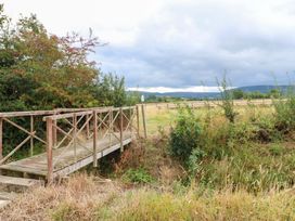 A bridge over grass and trees in a field at Cooper Cottage in Potto near Stokesley