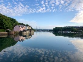 A view of houses and boats reflected in water at Curlew in Milford Haven