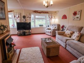 A living room with sofas and a television at The Lodge in Old Buckenham near Attleborough