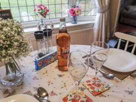 A dining table set with glasses and a bottle at The Lodge in Old Buckenham near Attleborough