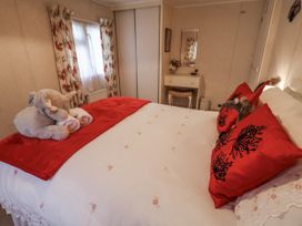 A bedroom with a bed and vanity table at The Lodge Old Buckenham near Attleborough