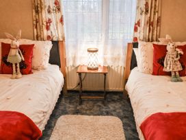 A bedroom with two beds and a lamp on a side table at The Lodge in Old Buckenham near Attleborough