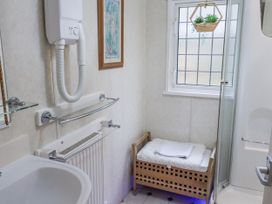 A bathroom with a shower, towel rack, and radiator at The Lodge in Old Buckenham near Attleborough