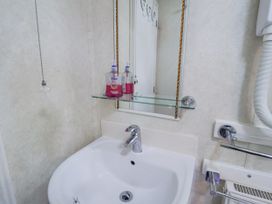 A bathroom with a sink and mirror at The Lodge in Old Buckenham near Attleborough