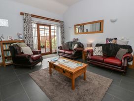 A living room with two sofas, a coffee table, and a bookshelf at Yr Hen Llaethdy near Newcastle Emlyn