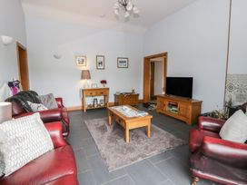 A living room with sofas and a television at Yr Hen Llaethdy in Blaen-Cil-Llech near Newcastle Emlyn