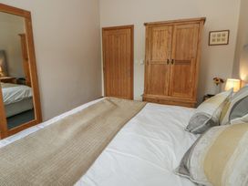 A bedroom featuring a bed with pillows and a wardrobe at Yr Hen Llaethdy near Newcastle Emlyn