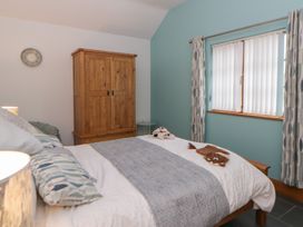 A bedroom with a bed and a wardrobe at Yr Hen Llaethdy in Blaen-Cil-Llech near Newcastle Emlyn