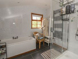 A bathroom with a bathtub and shower at Yr Hen Llaethdy Blaen-Cil-Llech near Newcastle Emlyn