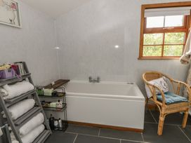 A bathroom with a bath tub and a towel rack at Yr Hen Llaethdy Blaen-Cil-Llech near Newcastle Emlyn