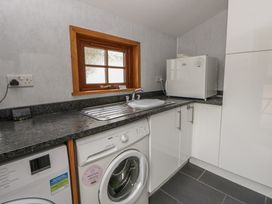 A utility room with a washing machine and sink at Yr Hen Llaethdy in Blaen-Cil-Llech near Newcastle Emlyn