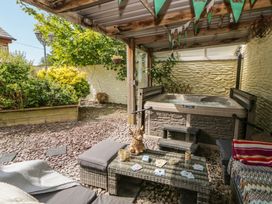A garden area with a hot tub and outdoor seating at Yr Hen Llaethdy in Blaen-Cil-Llech near Newcastle Emlyn