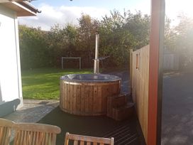 A hot tub with steps in a garden area at Kissane's Cottage, Beaufort, County Kerry