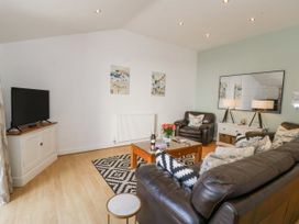 A living room with a television and coffee table at Maritime Mews, 6 The Oakleys in Porthmadog