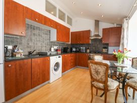 A kitchen with wooden cabinets and appliances at Maritime Mews, 6 The Oakleys, Porthmadog