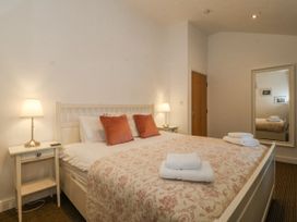 A bedroom with a bed and nightstand at Maritime Mews, 6 The Oakleys, Porthmadog