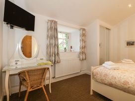 A bedroom with a bed, dressing table, and television at Maritime Mews, 6 The Oakleys Porthmadog