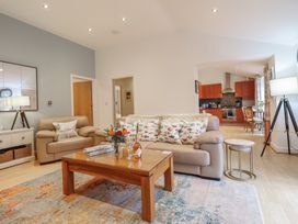 A living room with a sofa, coffee table and view of the kitchen at Maritime Mews, 6 The Oakleys, Porthmadog