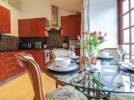 A kitchen with wooden cabinets and dining area at Maritime Mews, 6 The Oakleys, Porthmadog