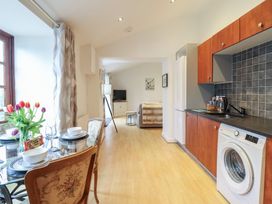 A kitchen area with a dining table and washing machine at Maritime Mews, 6 The Oakleys in Porthmadog
