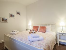 A bedroom with a bed and side table at Maritime Mews, 6 The Oakleys Porthmadog