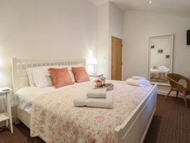 A bedroom with a bed and bedside table at Maritime Mews, 6 The Oakleys, Porthmadog