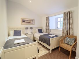 A bedroom with two beds and a nightstand at Maritime Mews, 6 The Oakleys in Porthmadog