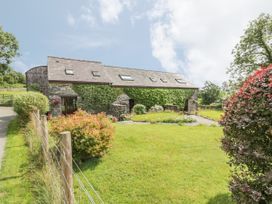 Stone house with ivy on the walls and a garden with bushes and grass at Arfron Penrhyddion Pella in Capel Garmon near Betws-y-Coed