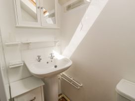 A bathroom with a pedestal sink mirror cabinet and small storage unit at Arfron Penrhyddion Pella in Capel Garmon near Betws-y-Coed