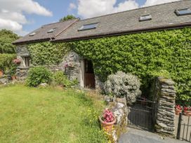 Stone cottage covered in ivy with a front garden and a black metal gate at Meifod Penrhyddion Pella in Capel Garmon near Betws-y-Coed
