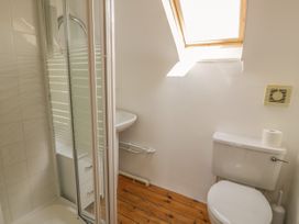 A bathroom with a shower enclosure a toilet a small sink and a window at Meifod Penrhyddion Pella in Capel Garmon near Betws-y-Coed