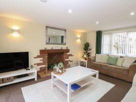 A living room with a television and coffee table at Sleepeezy in Little Snoring