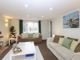 A living room with sofas and a table at Sleepeezy in Little Snoring