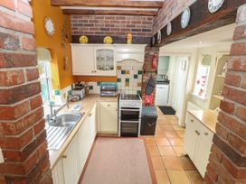 A kitchen with cabinets and a stove at Sleepeezy in Little Snoring