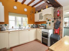 A kitchen with cabinets and a sink at Sleepeezy in Little Snoring