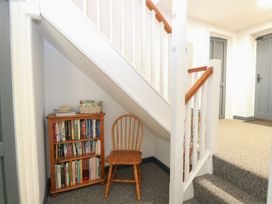 An entrance hall with a bookshelf and a chair at Sleepeezy in Little Snoring