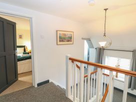 A hallway with a staircase and a door leading to a bedroom at Sleepeezy in Little Snoring