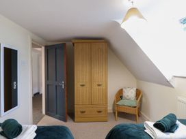 A bedroom with wardrobe and chair at Sleepeezy in Little Snoring