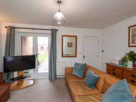 A living room with a sofa and television at Berry Banks Cottage in Whitby