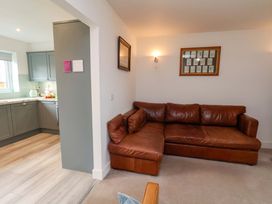 A living room with a sofa and kitchen area at Berry Banks Cottage in Whitby
