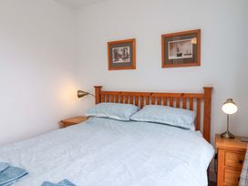 A bedroom with a bed and bedside table at Berry Banks Cottage, Whitby