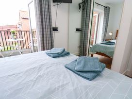 A bedroom with a bed and towels on it at Berry Banks Cottage in Whitby